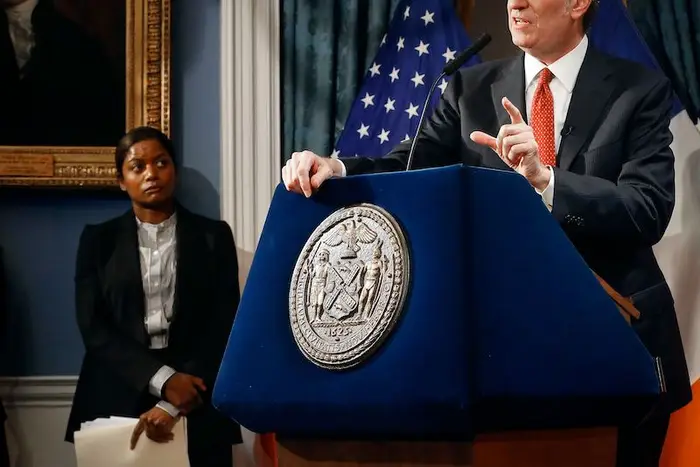 OMB Director Melanie Hartzog listens as Mayor Bill de Blasio speaks in a 2018 photo at a press conference at City Hall in New York.